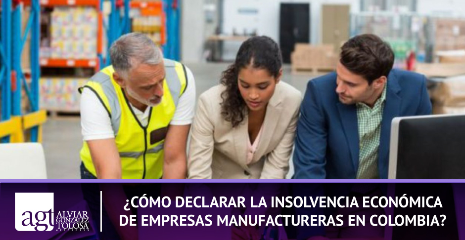 ¿Cómo Declara la Insolvencia Económica de Empresas Manufactureras en Colombia? Personas en Fabrica Manufacturera Viendo sus Finanzas