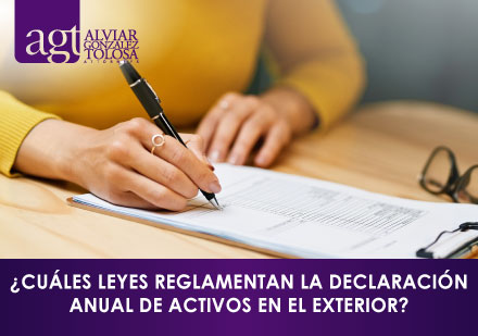 ¿Cuáles Leyes Reglamentan la Declaración Anual de Activos en el Exterior? Mujer Firmando Documento